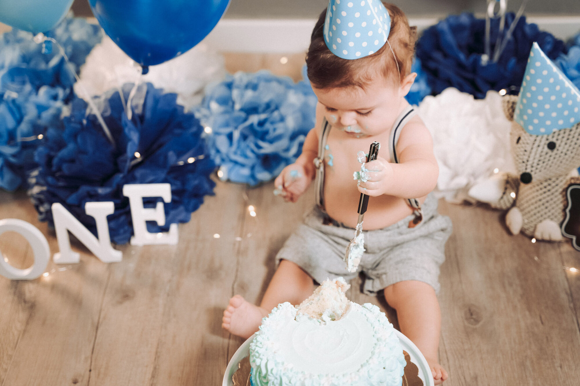 Bambino con cappellino di compleanno davanti alla torta