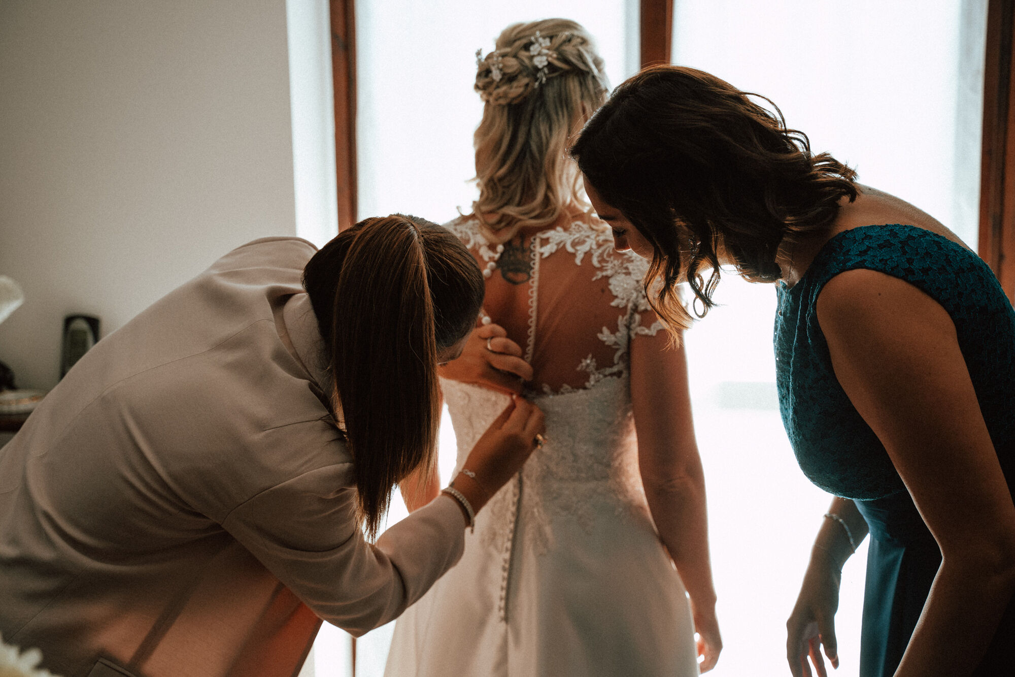 La sposa durante la vestizione, aiutata dalle amiche