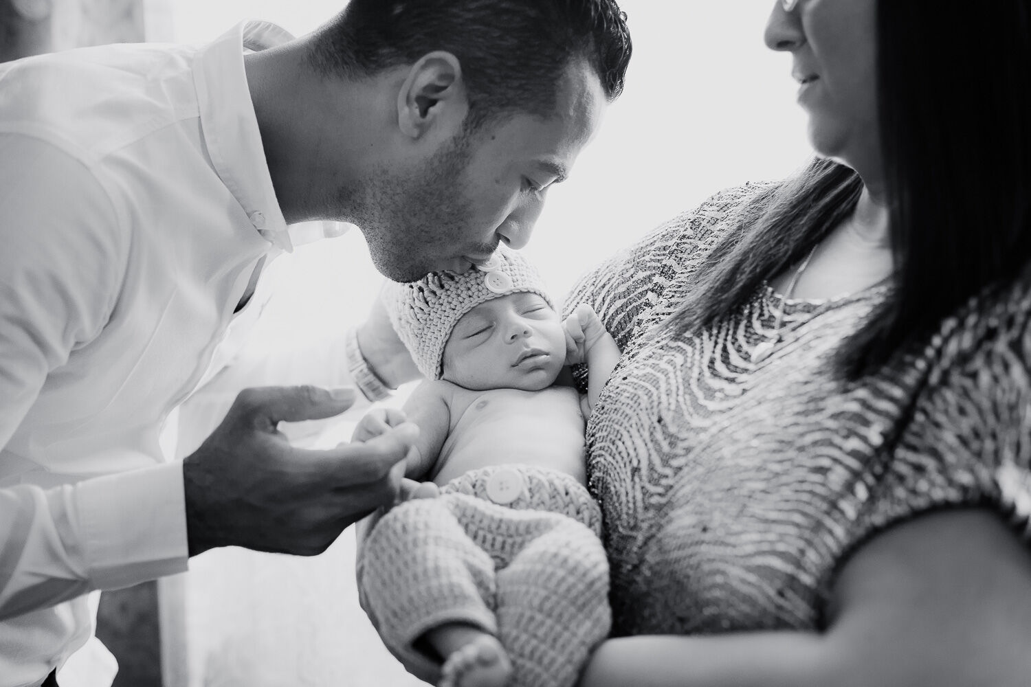 Mamma e papà con il neonato tra le braccia, fotografia in bianco e nero